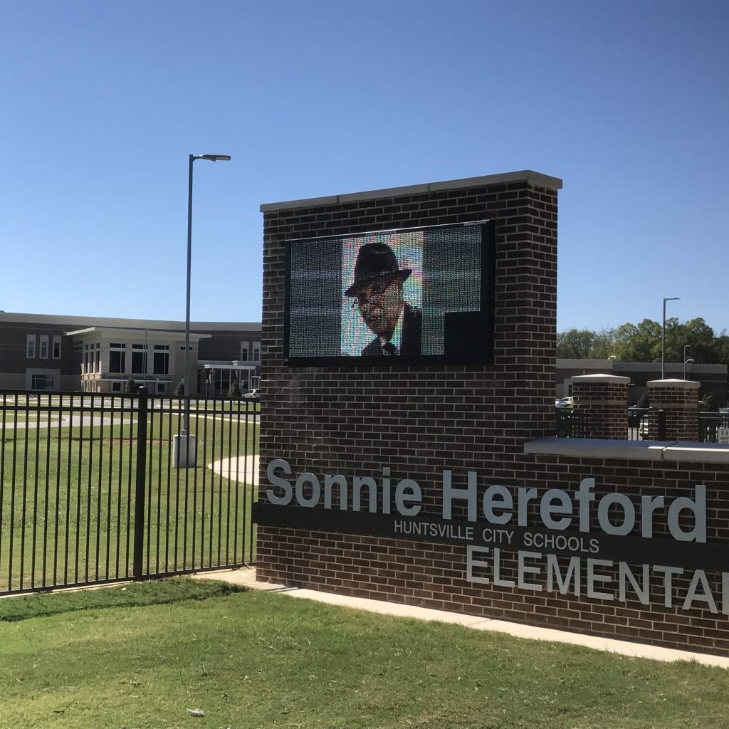 Sonnie Hereford, whose face is seen on video message board, was civil rights pioneer