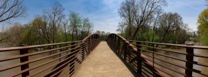 An elevated walking bridge crosses the Flint River at Hays Nature Preserve in Huntsville