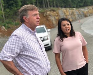 Huntsville Mayor Tommy Battle and Director of Engineering Kathy Martin stand on the shoulder of Cecil Ashburn Drive with a City vehicle in the background