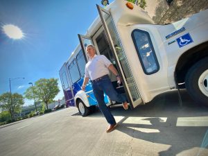 Tommy Brown steps off an Access paratransit bus onto the parking lot at Parking and Public Transit