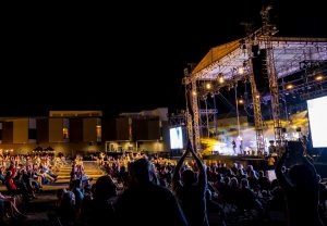 A crowd takes in a performance by the Black Jacket Symphony in the North Hall parking lot at the VBC arena.