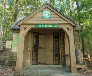 An old brick and wood building marked CCC Museum is seen at Monte Sano State Park. There are trees in the background.
