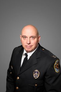 A portrait of Huntsville Police Capt. Mike Izzo, who is wearing a dress uniform and has a shaved head.