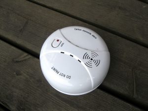 A photo of a carbon monoxide alarm on a wooden table.