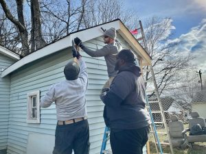 Volunteers replace fascia board on a home in the Terry Heights neighborhood in Huntsville.