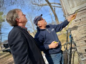 Huntsville Mayor Tommy Battle, left, and Rob Peavy of Community Development survey a home repair project in the Terry Heights neighborhood. The Mayor is wearing a black sport coat. Peavy has a tape measure.
