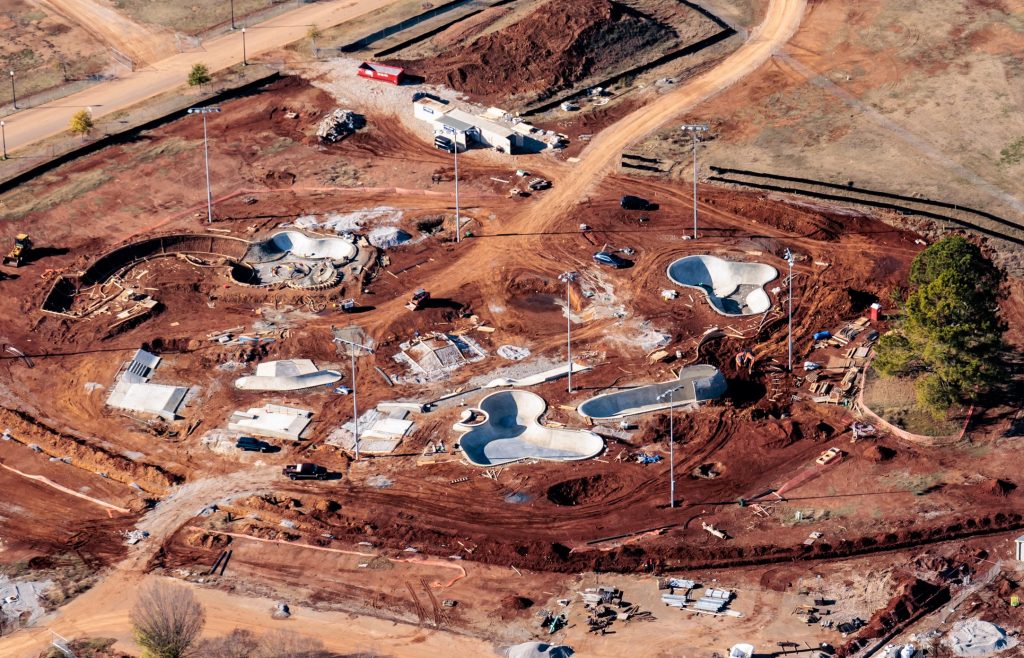 An aerial view of the new Get-A-Way Skatepark. There are bowls poured and much red dirt all around the site.