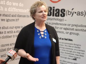 Cindy Hewitt, the Director of the Huntsville Madison County Public Library (HMCPL) system, explains "The Bias Inside Us" exhibit to local media partners.