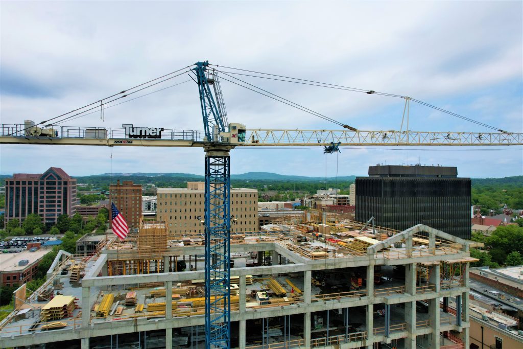 A large tower crane can be seen over downtown Huntsville at the site of the new City Hall.