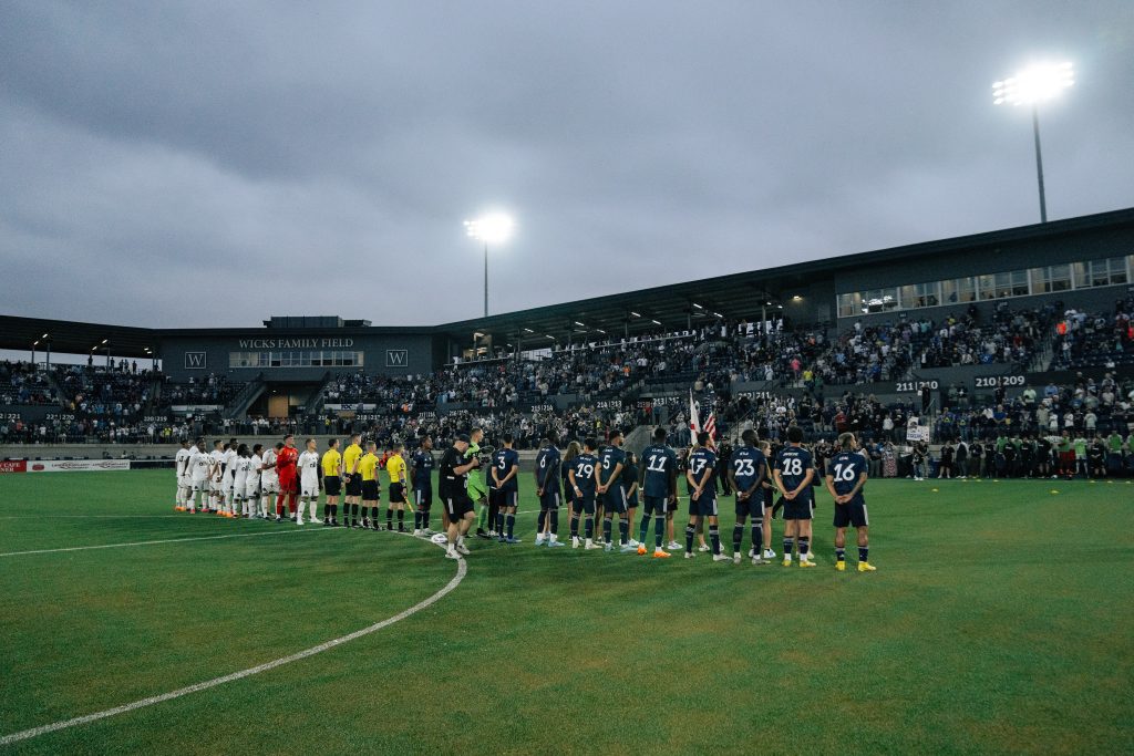 The HCFC and a visiting team line up on Wicks Family Field at Joe Davis Stadium for the national anthem. The team's kicked off its inaugural season in Huntsville in May 2023.
