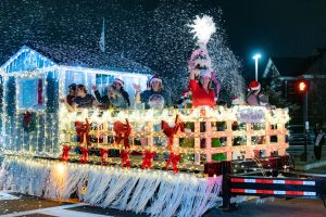 Huntsville residents wave from a snowy float during the Huntsville Christmas Parade in 2022.