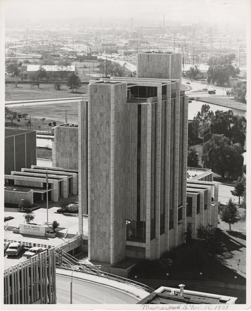 black and white photo of tall building with trees around it