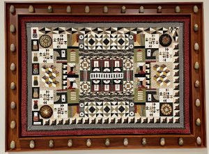 An artistic quilt featuring multiple different squares and patterns hanging on the sixth floor of city hall.