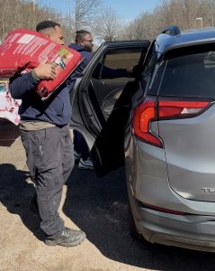 Two Huntsville Animal Services employees loading pet food into someone's car